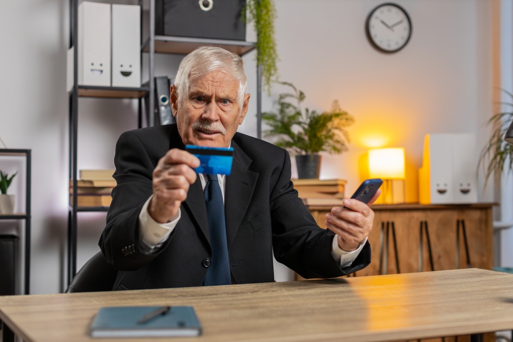 caucasian-angry-senior-businessman-trying-pay-online-with-smartphone-blocked-credit-card-home.jpg стол